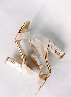 a pair of white high heeled shoes sitting on top of a white tablecloth