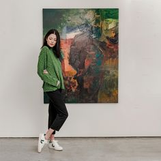 a woman standing in front of a painting