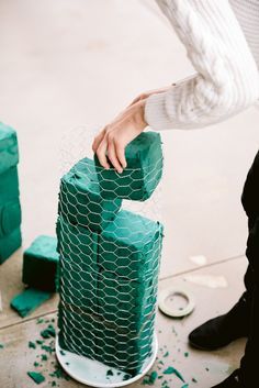 a person standing next to a green object