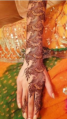 a woman's hand with henna tattoos on it