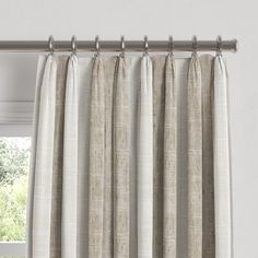 an open window with curtains hanging on the side and one curtain pulled down to reveal light