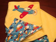 two baby bibs, one with an airplane on it