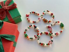 several bracelets made out of beads and bows on a table next to a gift box