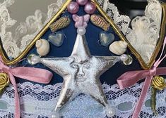 there is a silver star on top of a blue and white lace bra with pink bows