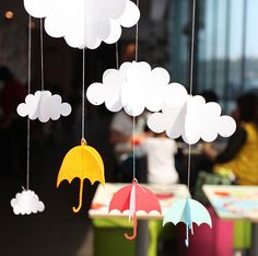 paper clouds and umbrellas hanging from strings