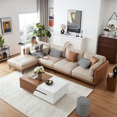 a living room filled with furniture and a white rug on top of a hard wood floor