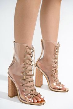 Make a statement with these chic transparent rose gold ankle bootie heels. These stylish shoes feature a lace up design for a customizable fit and a chic metallic finish that will elevate any outfit. Perfect for any special occasion or just for getting a bit of glamour into your everyday look. Party Ankle Boots With Laces, Summer Party Ankle Boot Heels, Party Lace-up Ankle Boots, Glamorous Summer Party Boots, Party Lace-up Boots With Wrapped Heel, Lace-up Party Boots With Wrapped Heel, Gold High Heel Summer Boots, Gold Boots With Block Heel For Spring, Metallic Boots For Party In Spring