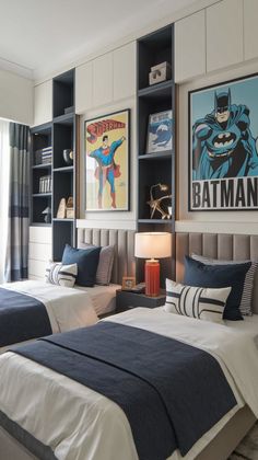 two beds in a bedroom with batman posters on the wall