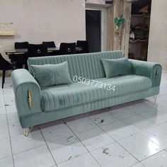 a blue couch sitting on top of a white tiled floor