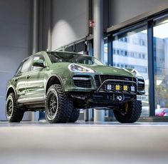 a green suv parked in front of a building