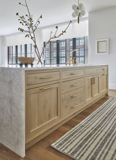 a large kitchen with marble counter tops and wooden cabinets, along with a rug on the floor