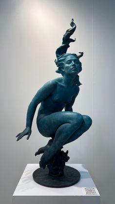 a blue statue sitting on top of a white pedestal