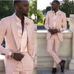 a man in a pink suit standing next to a wall