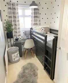 a bedroom with two bunk beds and a desk in the corner next to a window