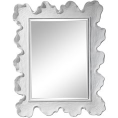 a white framed mirror sitting on top of a wall