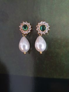 Amazing and OOAK Emerald green earrings, leave stunning impression on everyone! Very classic and has a glamour that can be achieved only with this white pearl and green stone crystals combination: beautiful Swarovski white drop pearls and green Emerald surrounded with tiny crystal Swarovski rhinestones.    I have a matching necklace: https://www.etsy.com/il-en/listing/90528659/bridal-necklace-genuine-emerald-stone?click_key=e18de233524584b28d69e078e8931ba7e38d1eef%3A90528659&click_sum=32f349a7&ref=shop_home_active_9&sts=1 A gorgeous shiny drop pearls earrings features Elegance and style: A beautiful pair made of golden filigree set with Swarovski rhinestone and vintage style pearls, tiny clear crystals and teardrop pearls that has such an impressive style. The back of the earring is ear pi Green Teardrop Pearl Earrings For Wedding, Green Drop Pearl Earrings For Wedding, Elegant Green Jewelry With Pearl Charm, Classic Green Earrings For Wedding, Green Pearl Drop Wedding Jewelry, Green Pearl Drop Jewelry For Wedding, Green Pearl Earrings For Wedding, Classic Green Pearl Drop Earrings, Green Elegant Pearl Drop Earrings