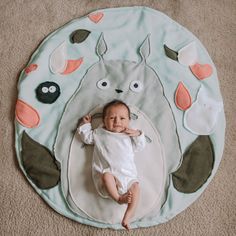 a baby laying on top of a rug