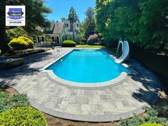 an empty swimming pool surrounded by trees and shrubbery with a slide in the middle