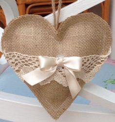 a heart shaped burlock hanging from a chair with a bow on the front