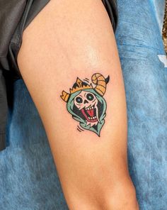 a person with a tattoo on their leg that has a skull and crown on it