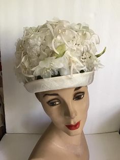 "Vintage 1960's hat. White floral with Green leaves bucket style hat. The label is *SEARS Fashion Millinery*. Sears Roebuck and Co. USA. *MORE INFORMATION BELOW* CONDITION: No issues noted. MEASURES: Inside circumference~21 1/2\" Height~5\" Front to back~8\" Left to right~7\" *WE APOLOGIZE~BUT WE NO LONGER SHIP TO GERMANY, ITALY OR SPAIN. IF ORDERS COME IN FROM GERMANY, ITALY OR SPAIN, WE WILL HAVE TO CANCEL THEM AND REFUND YOUR MONEY. SORRY FOR THIS INCONVENIENCE*" White Vintage Fascinator For Royal Ascot, White Vintage Cloche Fascinator, Vintage White Cloche Fascinator, Vintage White Fascinator Hat, White Vintage Fascinator Hat, Vintage White Mini Hat For Royal Ascot, White Vintage Top Hat With Curved Brim, Vintage White Top Hat For Formal Occasions, Vintage White Fascinator With Curved Brim