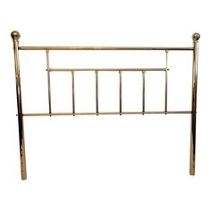 a gold metal headboard with four posts and two foot boards on each side, against a white background