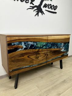 a wooden sideboard with an abstract painting on it