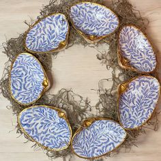 four blue and white plates sitting on top of a nest filled with hay covered in grass