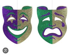 two masks with faces painted on them, one has a green and purple mardi gras mask