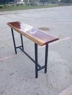 a wooden table sitting in the middle of a parking lot