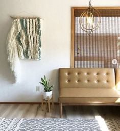 a living room with a couch, rug and hanging decorations on the wall above it