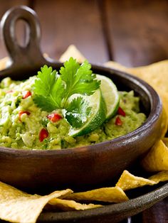 guacamole in a bowl with chips on the side