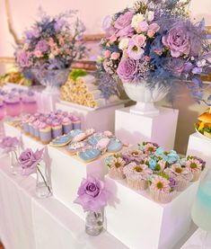 a table topped with lots of cupcakes and cakes