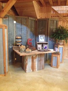 a wooden table topped with lots of pastries on top of a floor next to a wall