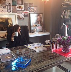 a woman sitting at a desk with a cup in her hand