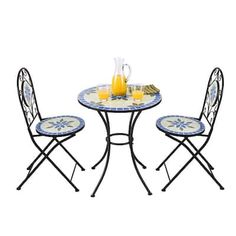 a table with two chairs and a pitcher of orange juice sitting on top of it