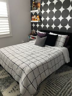 a bedroom with black and white decor on the walls, carpeted flooring and a large bed