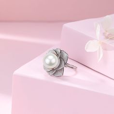 This elegant ring features a stunning 11-12mm white freshwater pearl accented by a brilliant 11-12mm Miya zirconia flower. The open closure design adds a modern touch to this timeless piece. Expertly crafted, this ring is a must-have for any pearl lover's collection. Material: 925 Sterling Silver, 4A freshwater pearl, and cubic zirconia Flexible size with open closure Elegant Cubic Zirconia Flower Ring, Elegant White Gold Flower Ring With Cubic Zirconia, Elegant Silver Flower Shaped Ring, Elegant White Flower Ring, Elegant Sterling Silver Flower Ring, Elegant Silver Flower Ring For Formal Occasions, Elegant White Flower Shaped Ring, Elegant White Flower Shape Ring, Elegant White Flower-shaped Ring