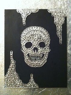 a drawing of a skull made out of chains on a piece of black paper with silver foil