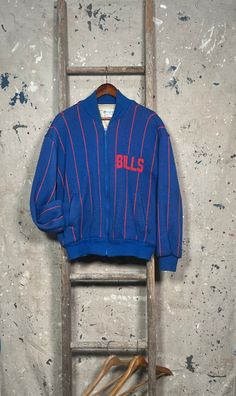 Extremely rare 1980s Buffalo Bills Cliff Engle jacket by Pro Elite. Officially licensed NFL product . Pin stripe , fully lined knit sweater jacket. Made in USA. Perfect size , fits like large. Like new , never worn condition . Brand: Cliff Engle by Pro Elite Size: tagged Medium , fits Large  Bust : 22  inches Sleeve: 21 inches Length: 27 inches Retro Oversized Crew Neck Outerwear, Vintage Varsity Jacket With Ribbed Cuffs For Winter, Vintage Long Sleeve Wool Varsity Jacket, Retro Crew Neck Outerwear With Ribbed Cuffs, Vintage Long Sleeve Varsity Jacket With Ribbed Cuffs, Vintage Crew Neck Outerwear For Winter, Retro Streetwear Cardigan For Fall, Retro Long Sleeve Track Jacket For Winter, Vintage Wool Crew Neck Outerwear