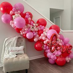 the balloon arch is decorated with pink, red and white balloons that spell out love