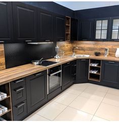 a kitchen with black cabinets and wooden counter tops