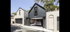 a car is parked in an open garage door on the side of a house that has two garages