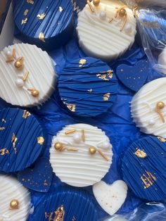 blue and white cupcakes with gold decorations on them