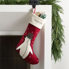 a christmas stocking hanging on the wall with toothbrushes and toothpaste in it