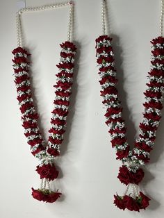 two red and white necklaces hanging on a wall