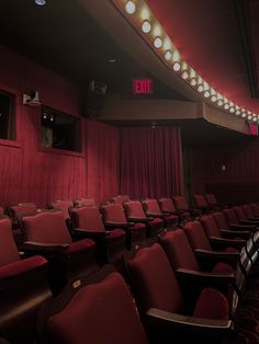 an empty theater with red chairs and lights