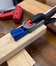 a pair of pliers on top of a piece of wood next to some tools