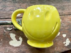 a yellow mug with a smiley face on it