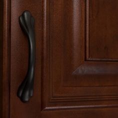 a close up of a door handle on a wooden door with dark wood grains